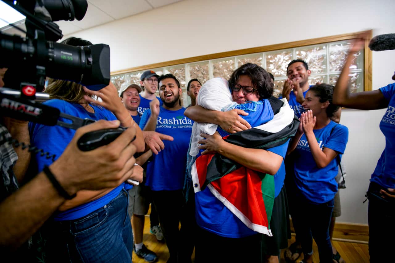Rashida Tlaib embraces her mother Fatima Elabed, who wears a Palestinian flag across her shoulders, as they celebrate in Detroit after Tlaib won the Democratic primary race to succeed longtime Rep. John Conyers (D-Mich.) on Tuesday, Aug. 7, 2018.