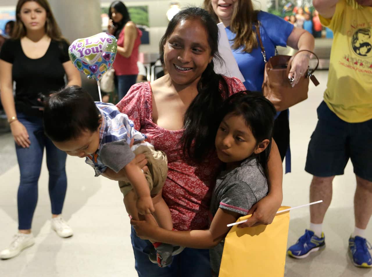 Buena Ventura Martin-Godinez holds her son Pedro as she and her daughter are reunited.