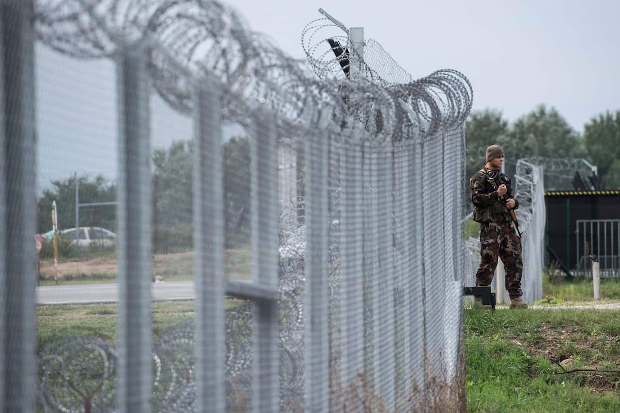 (File Image) A Hungarian soldier patrols the transit zone at Hungary's southern border with Serbia in 2016.