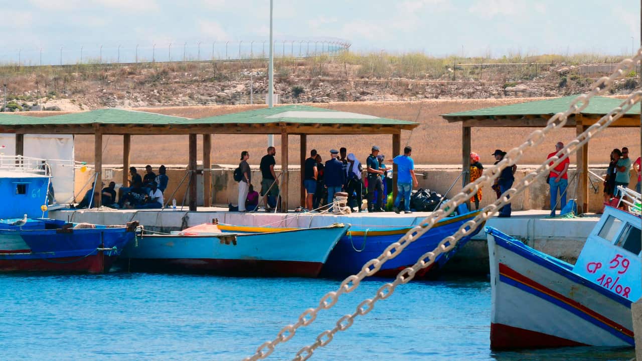 Migrants wait to disembark from a vessel in Lampedusa harbour, 2 September 2019. 