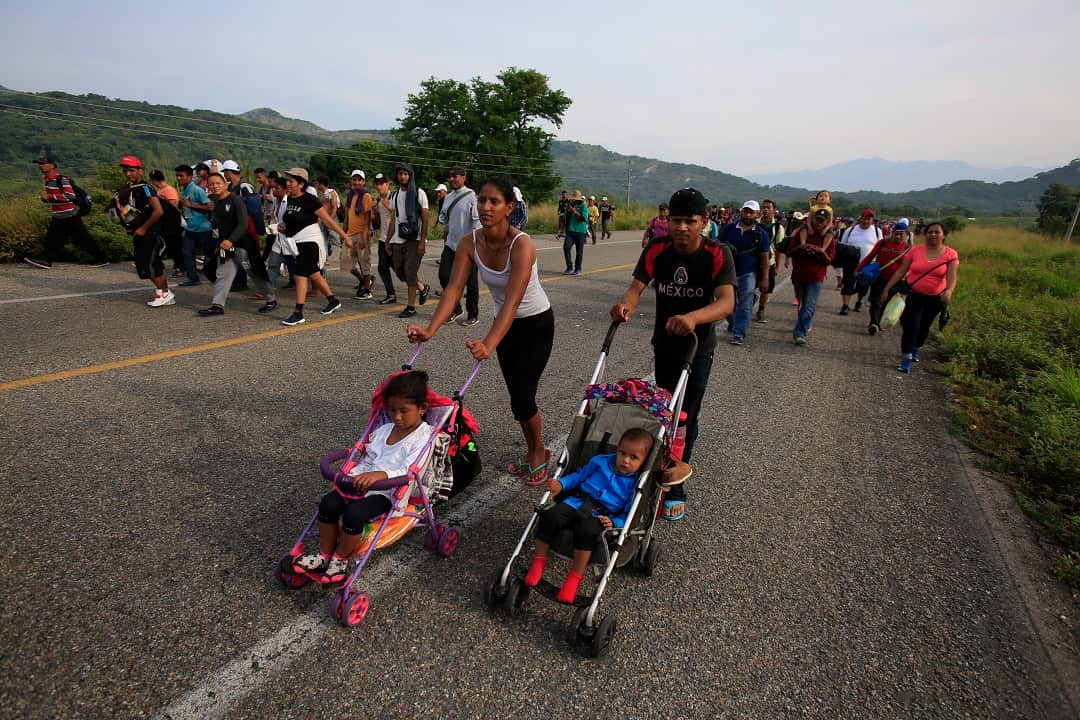 Migrants push strollers carrying young children as their caravan pushes on through Mexico.