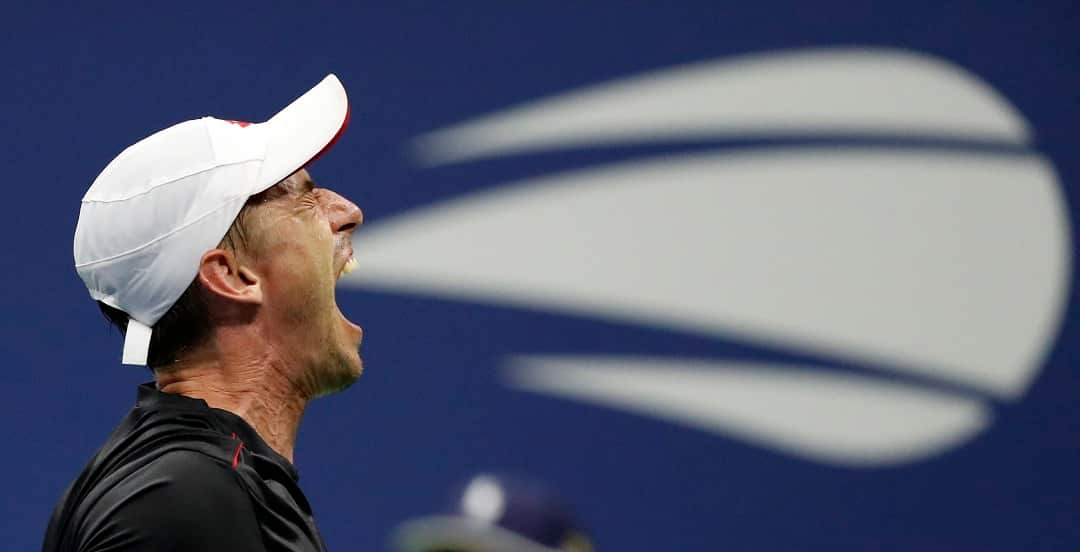 John Millman fires himself up during the game against Roger Federer.