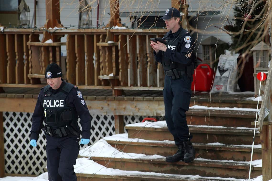 Toronto police forensic officers walk out of a house in Madoc, Ont. on Friday, January 19, 2018. 