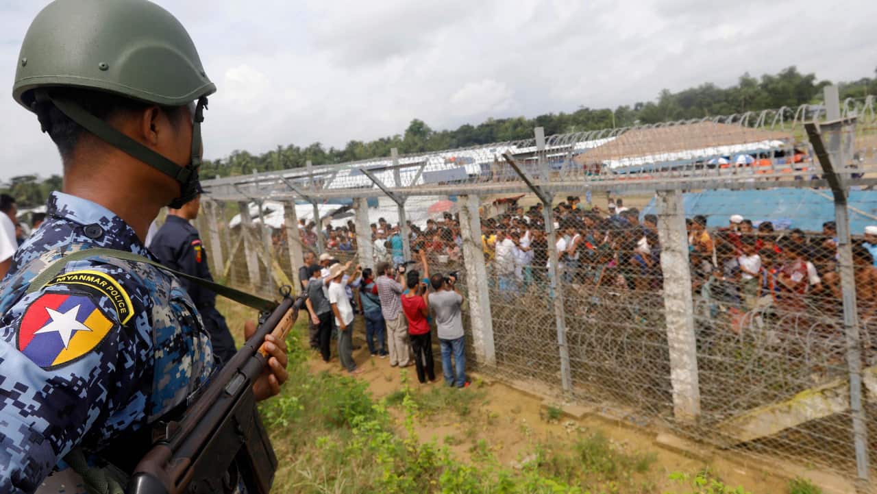 A Myanmar border guard police stands guard near a fence of Rohingyas refugees at the 'no man's land' zone between the Bangladesh-Myanmar border.