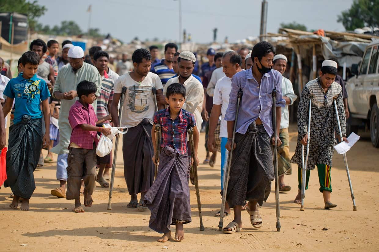Wounded Rohingya refugees walk with the help of crutches at the Kutupalong Rohingya refugee camp.