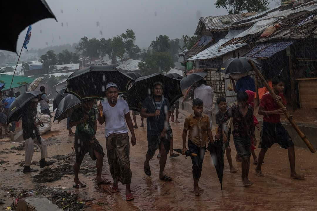 Rohingya refugees walk through heavy rain at the Kutupalong refugee camp in Bangladesh.