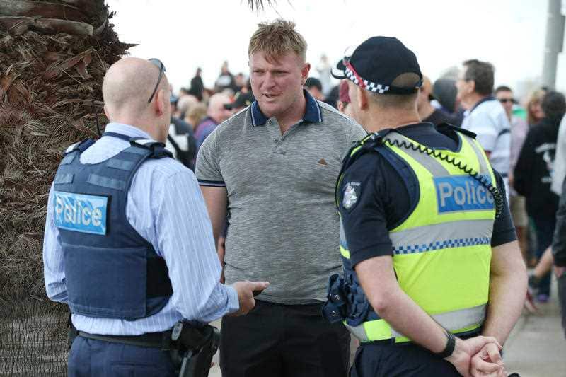 Right wing activist Blair Cottrell is seen talking to police on St Kilda foreshore.