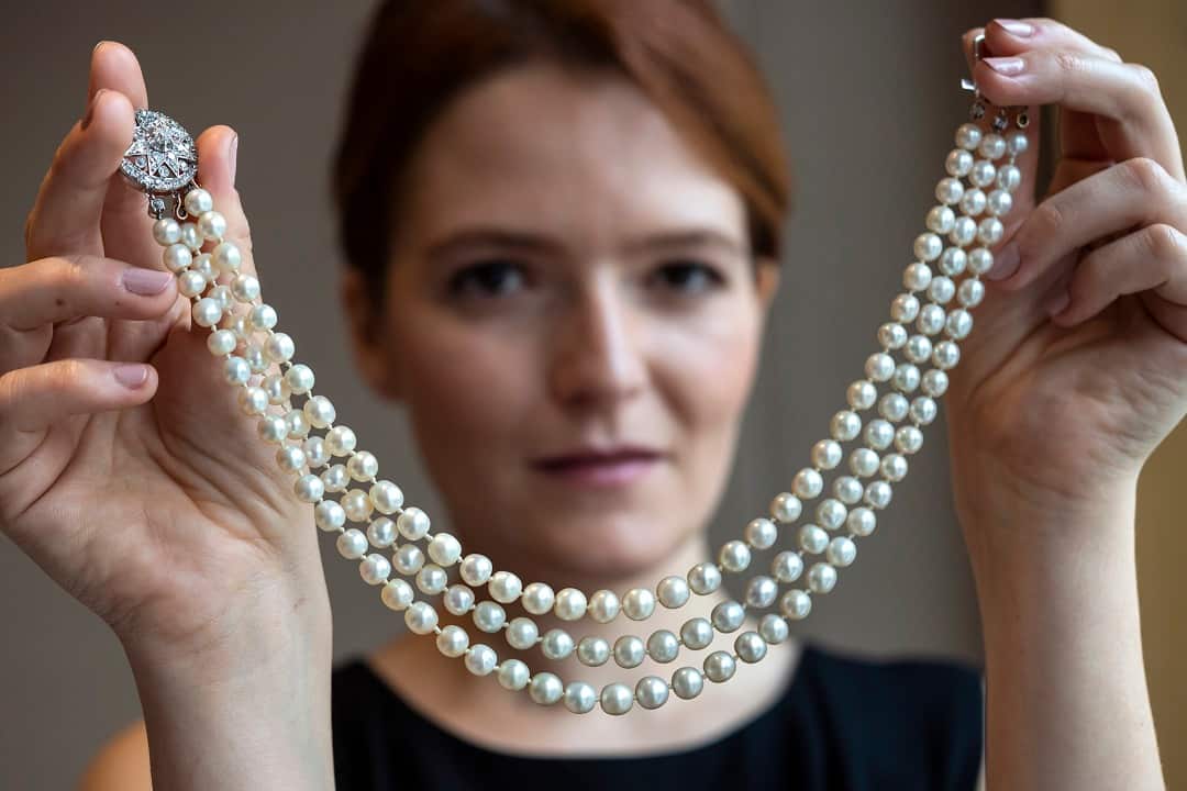 A Sotheby's employee displays the natural pearl and diamond necklace that once belonged to Marie Antoinette.