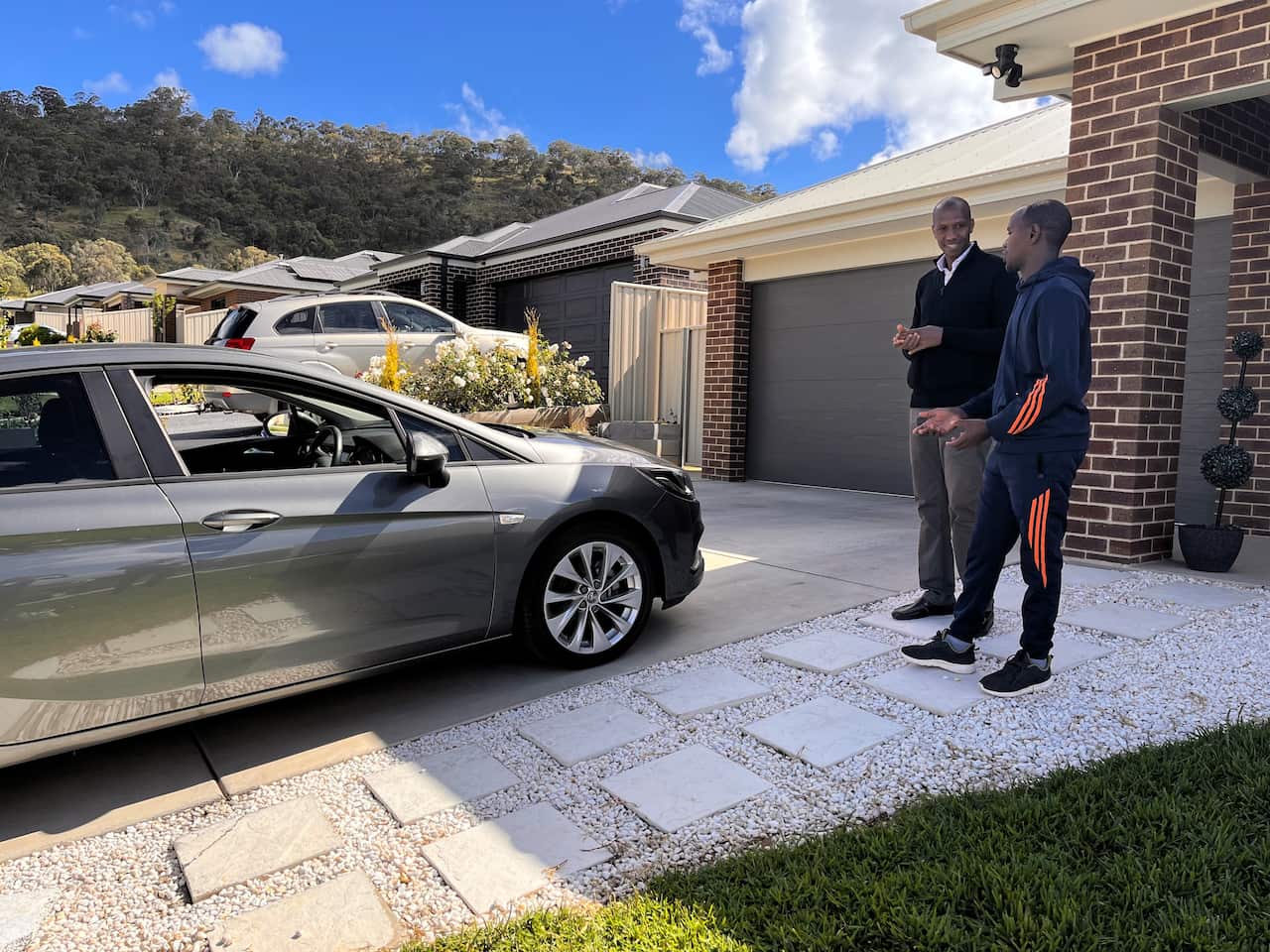 Nelson and Masange examine the car on loan for the drivers education program