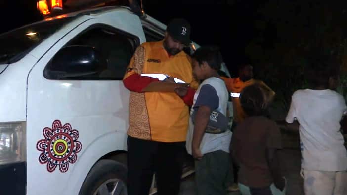 Kids line up to board the Night Patrol bus.
