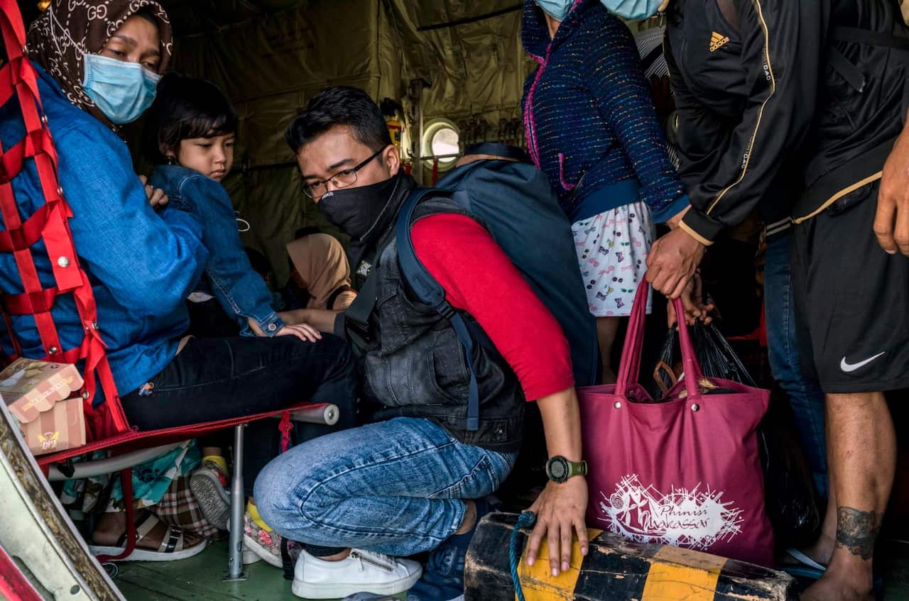 Evacuees board a military flight in Palu, Indonesia on Tuesday, Oct. 2, 2018.
