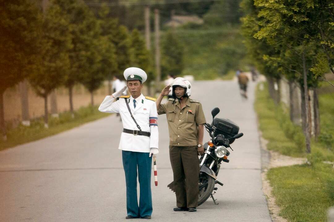 Members of the North Korean military salute Mike Pompeo's motorcade.