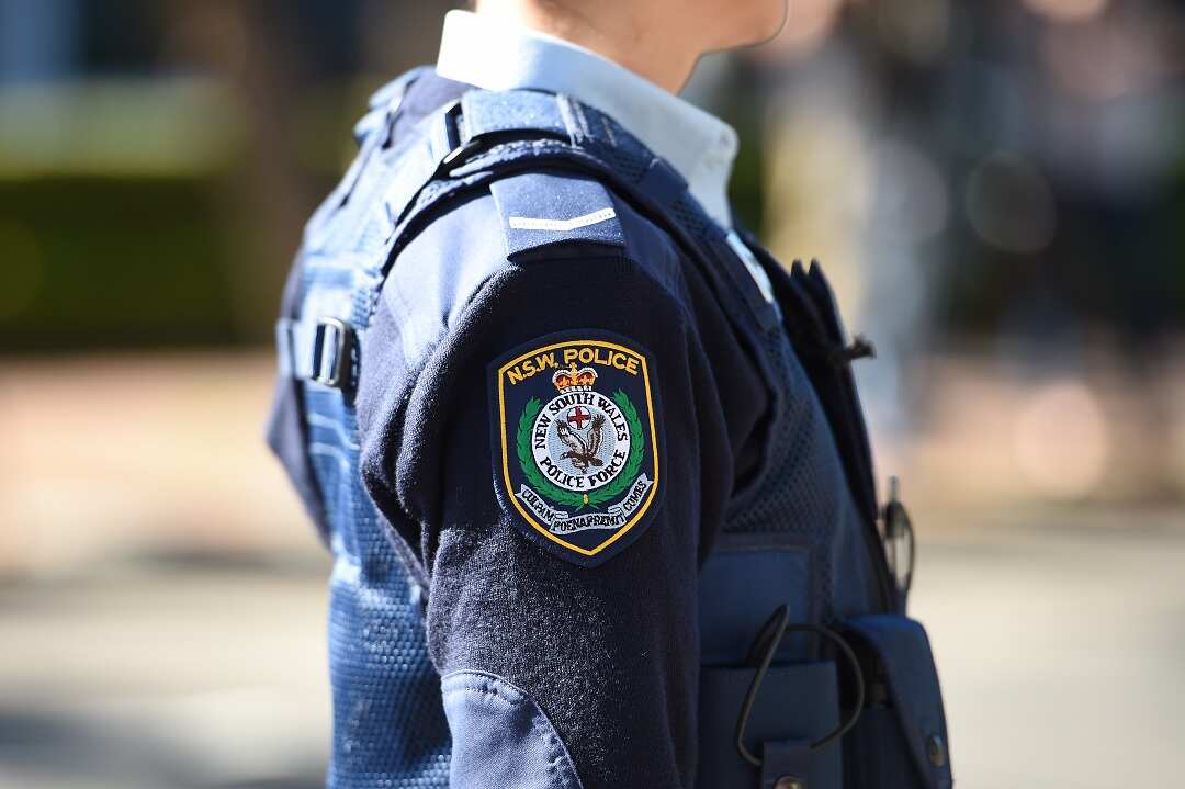 A person in uniform with the NSW Police logo on it.