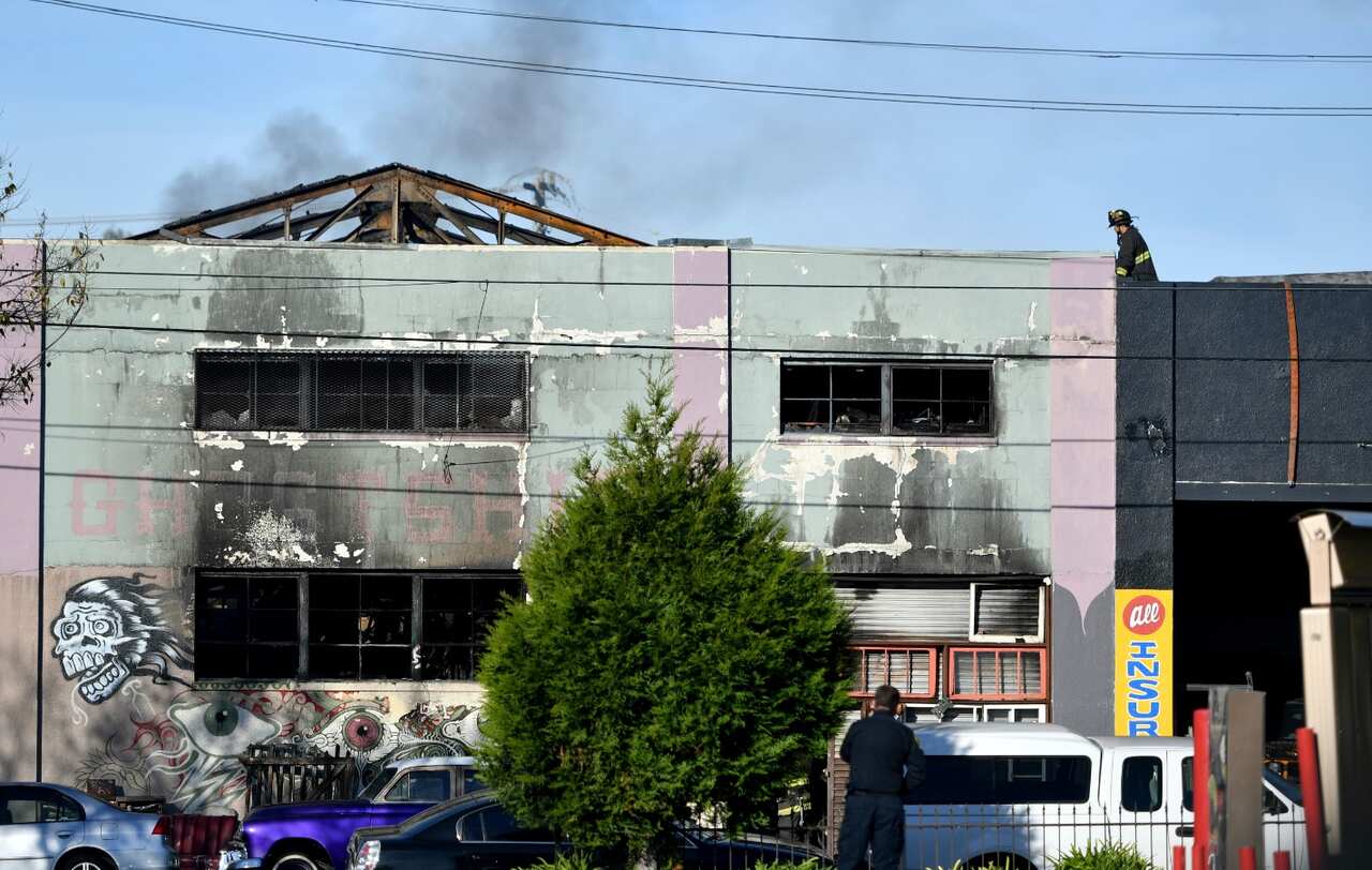 Firefighters work at the aftermath of a warehouse fire in the Fruitvale district of Oakland at the corner of 31st (AAP)