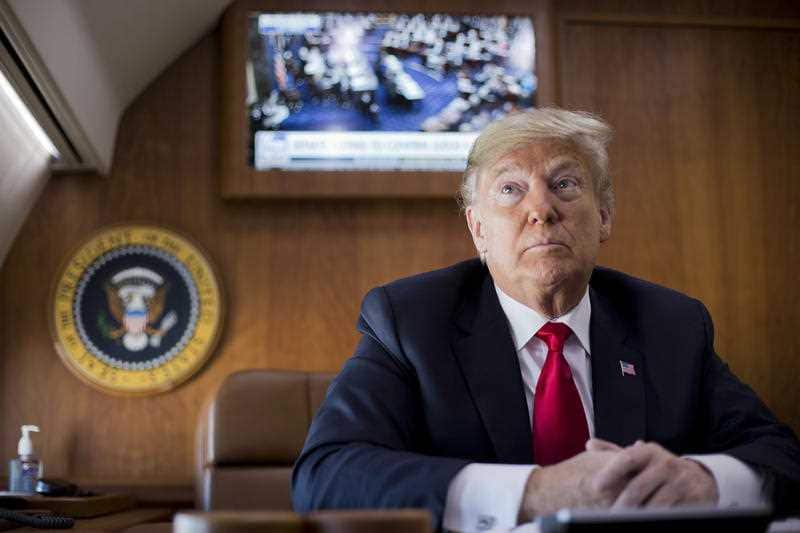 President Donald Trump, on board Air Force One, pauses while watching a live television broadcast of the Senate confirmation vote of his Supreme Court nominee.