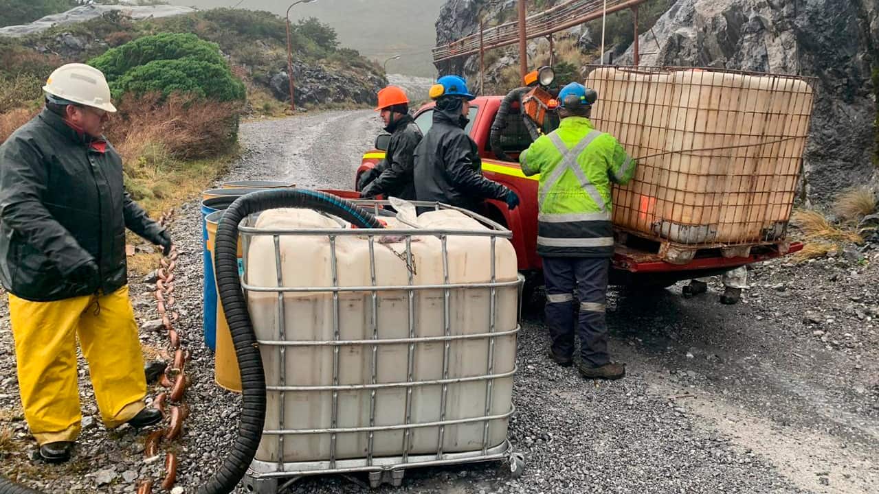 Sailors work to contain damage from an oil spill, on Guarello Island in Chile.