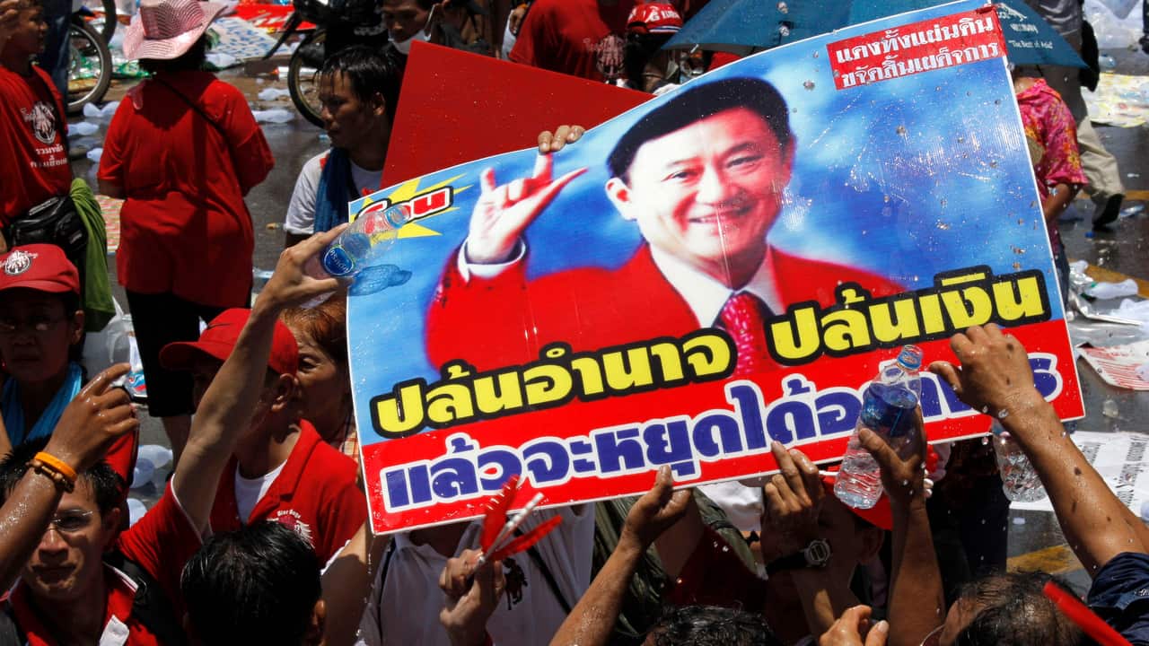 Protesters put water on picture of ousted Prime Minister Thaksin Shinawatra after leaders called off their rally outside the government house in Bangkok.