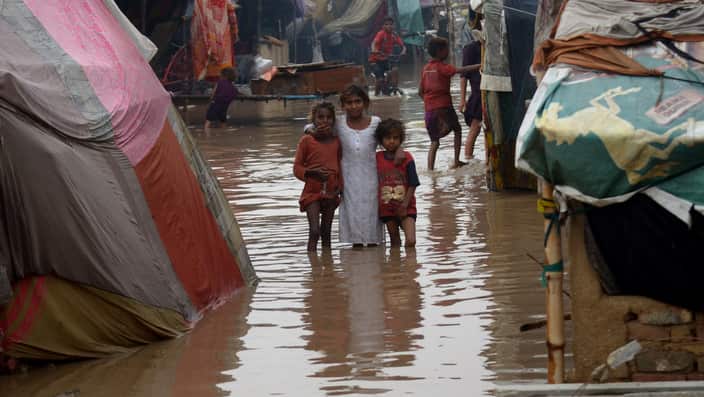 Children stand in floodwaters after intense monsoon rains hit the city of Lahore.
