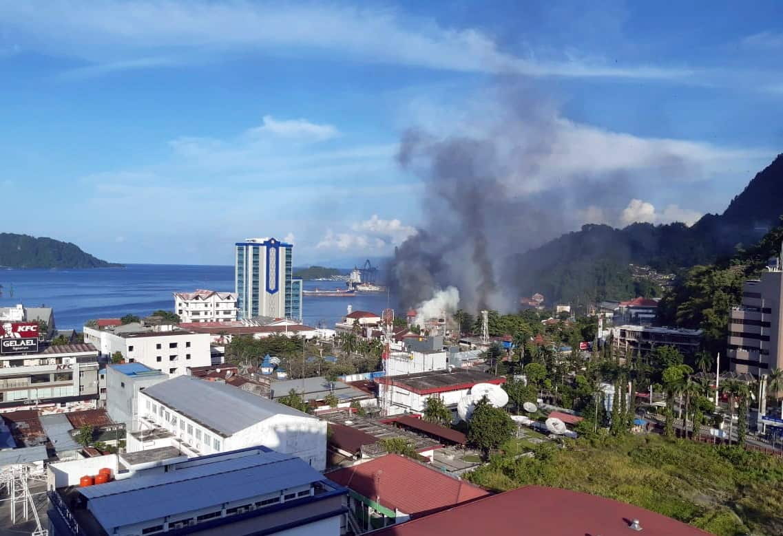 Smoke raises from a burning building during a violent protest in Jayapura, Papua Province, Indonesia.