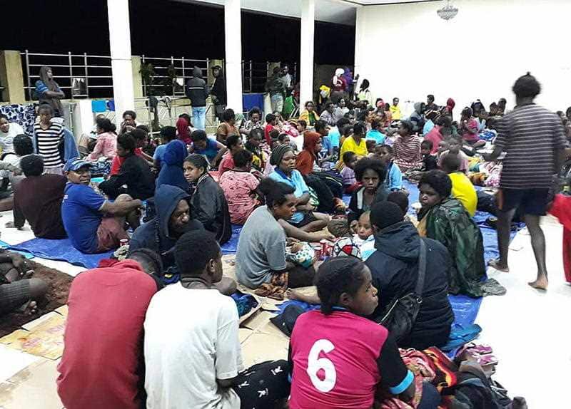 Residents gathering at a temporary shelter as flash floods rage. 