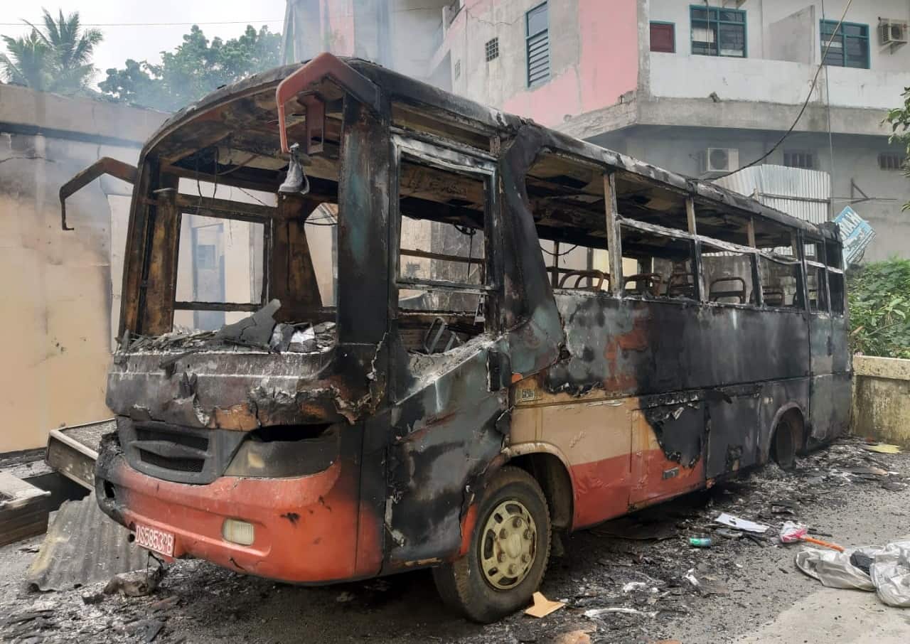 A burnt bus sits outside the parliament building during the protest.