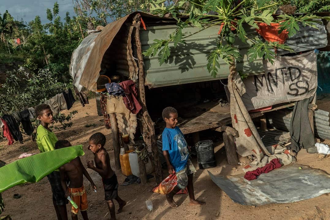 A group of young boys come out of a family shack in the Gehrehu settlement of Port Moresby, Papua New Guinea.