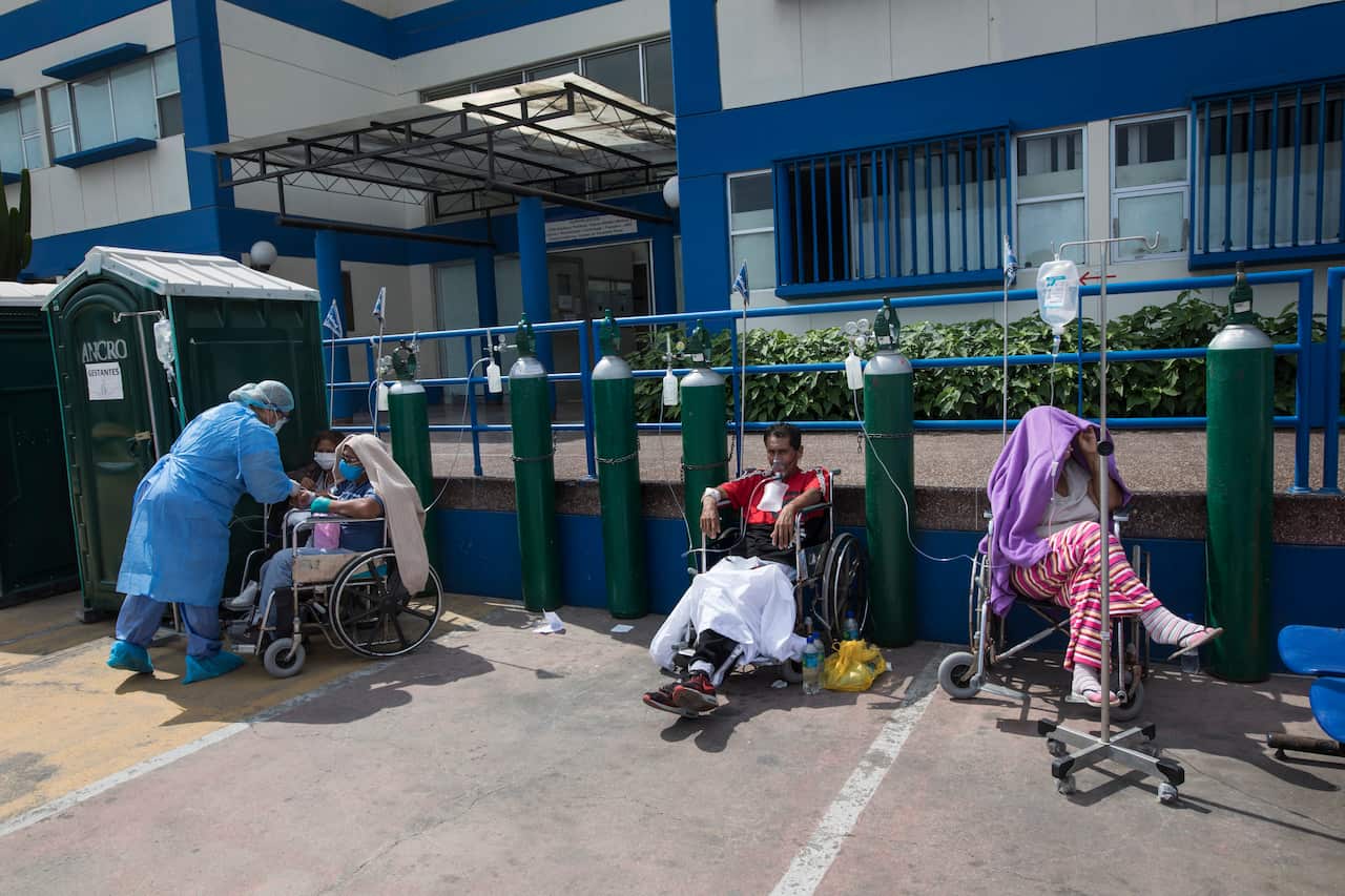 People infected with Covid-19 disease wait for an available bed, outside a public hospital in Lima, Peru (AAP)