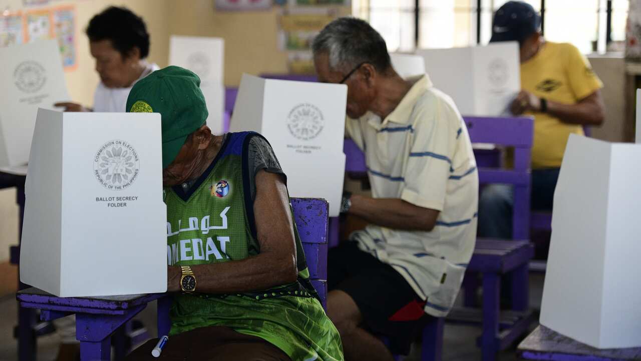 Filipino residents casts their votes in the national mid-terms elections at a polling station in Manila.