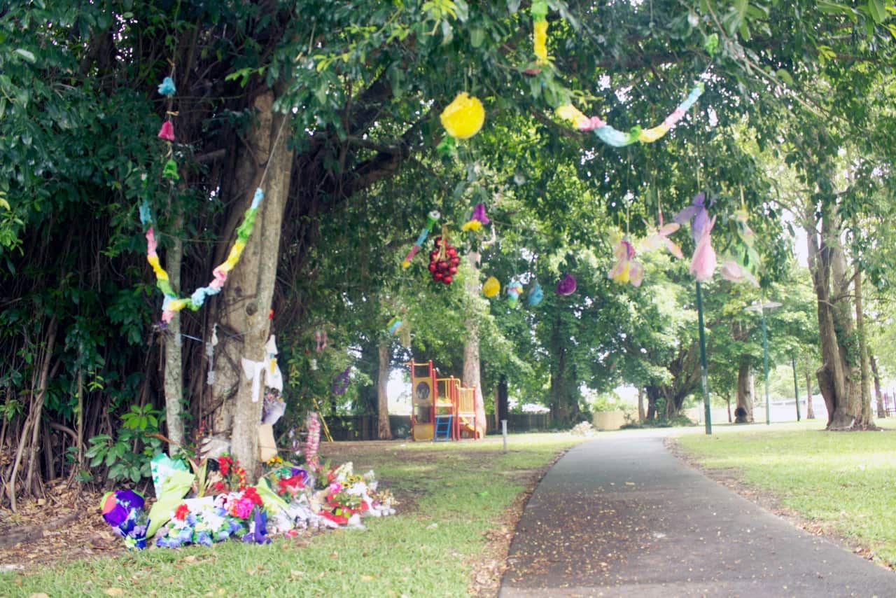 Floral tributes on Thursday lay near the home where the lives of eight children were taken before Christmas last year in Cairns in far north Queensland.