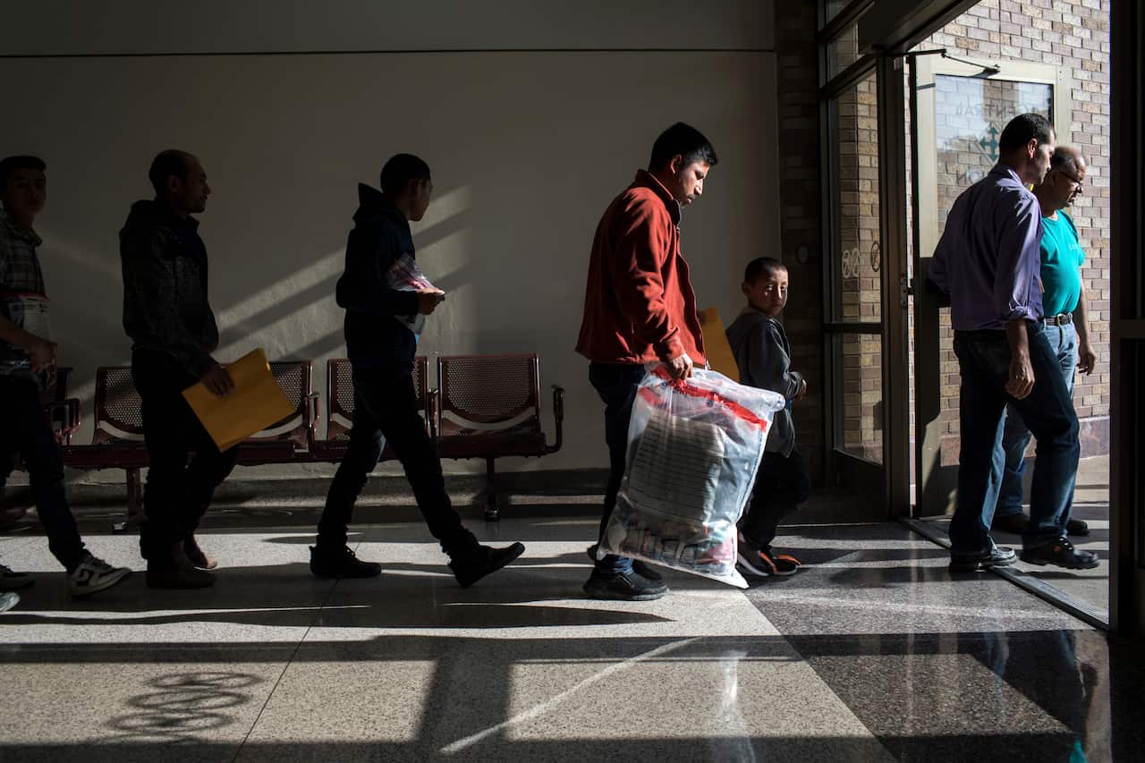 Undocumented immigrants walk from a bus station in McAllen, Texas.