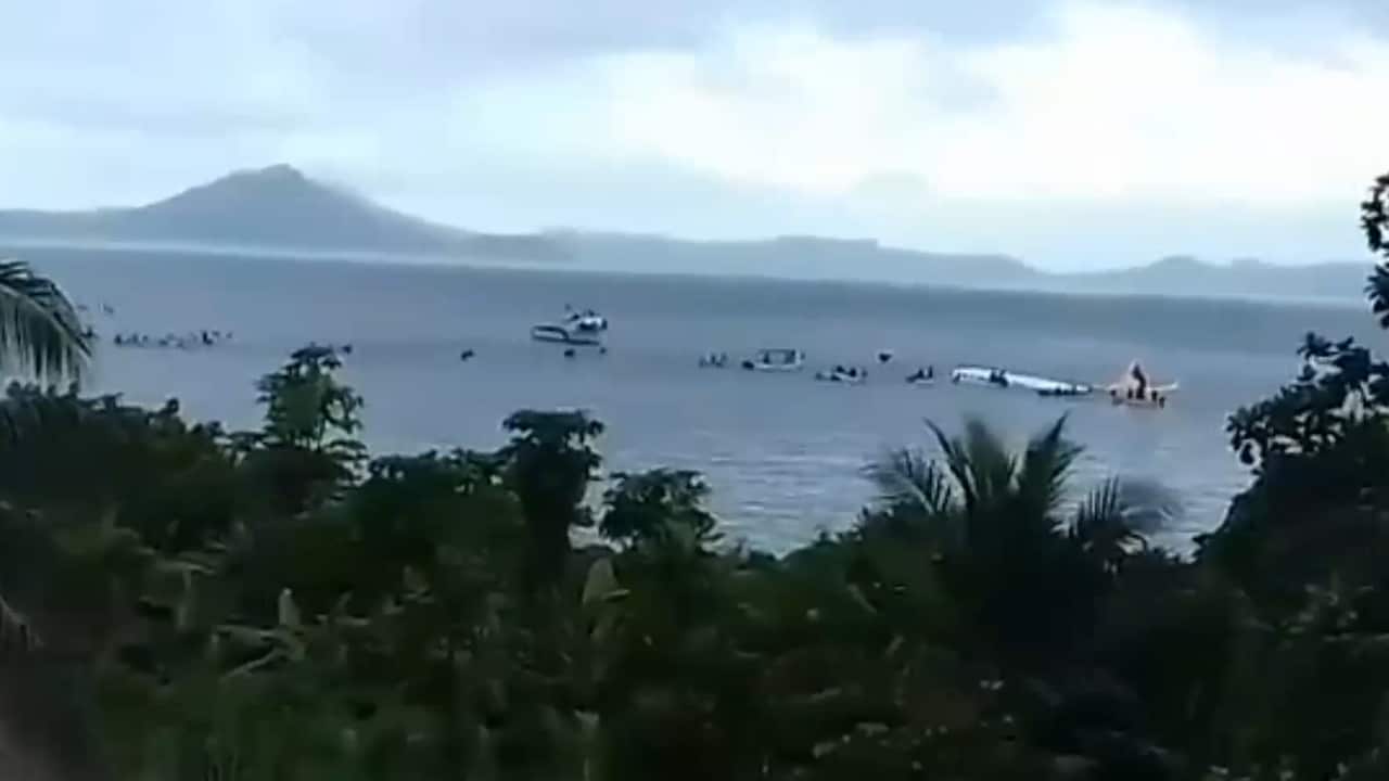 Small boats race to the crashed plane.