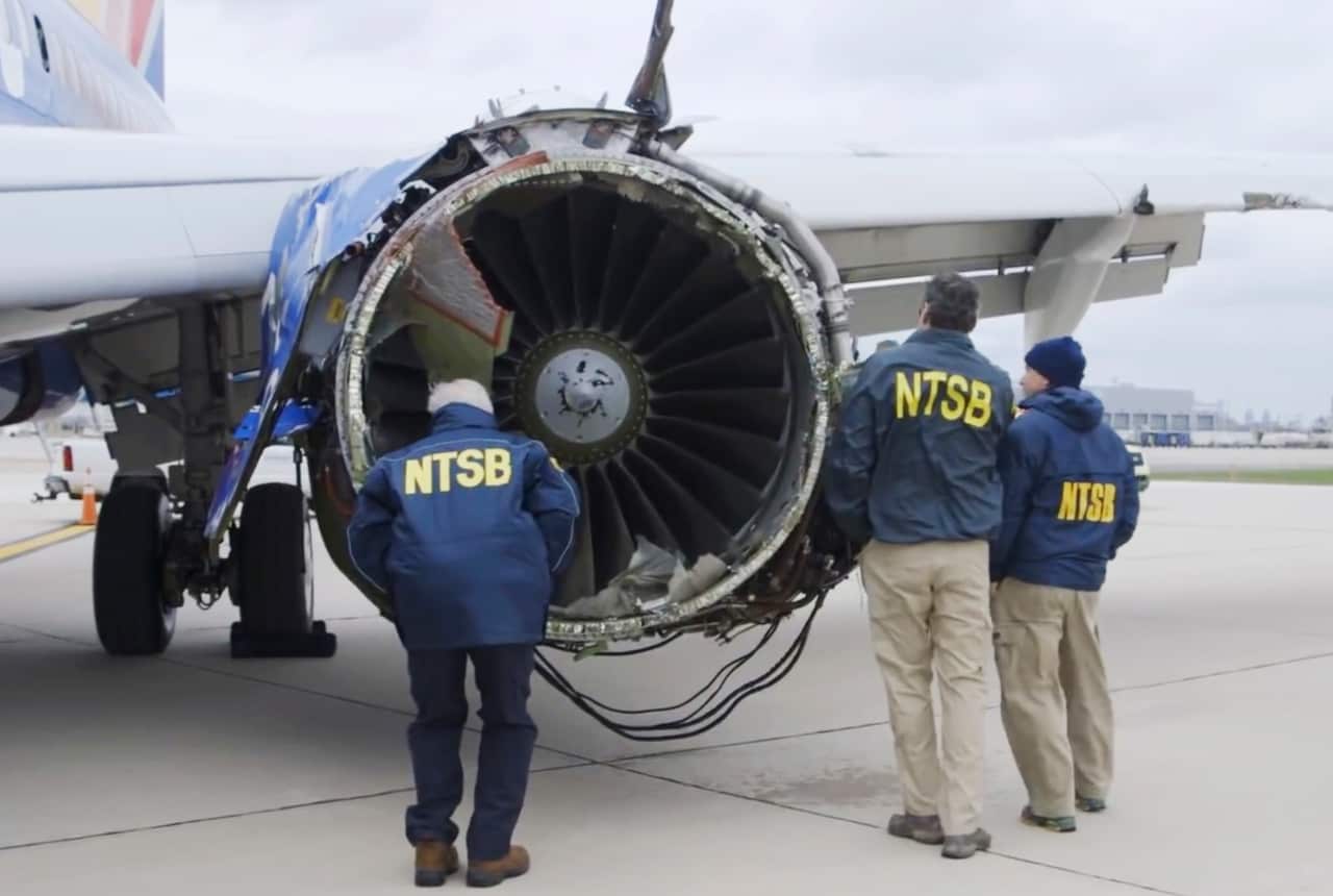 In this Tuesday, April 17, 2018 frame from video, a National Transportation Safety Board investigator examines damage to the engine of the plane