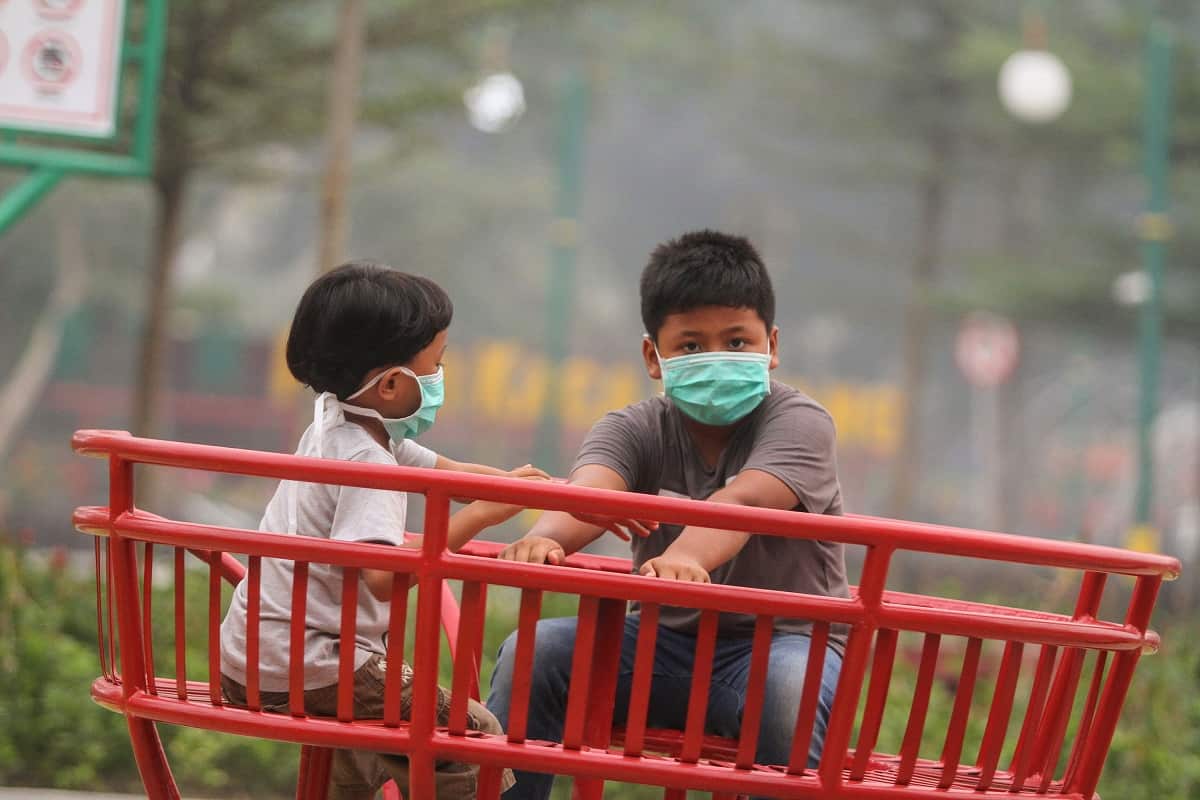 Indonesian boys wear masks due to haze as they play at a playground in Pekanbaru, Riau province, Indonesia, 14 September 2019, as schools are closed due to the thick haze. 