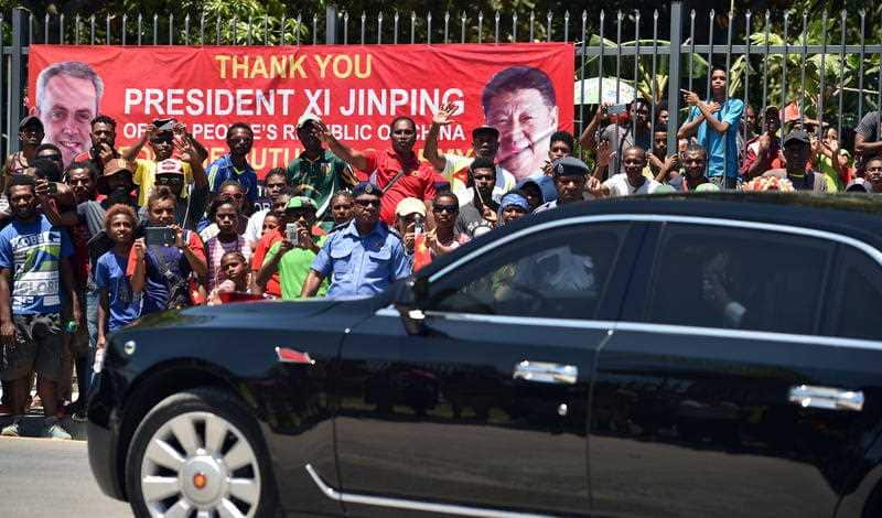 Locals watch as Chinese President Xi Jinping's motorcade leaves the Butuka Academy school, ahead of the APEC summit.