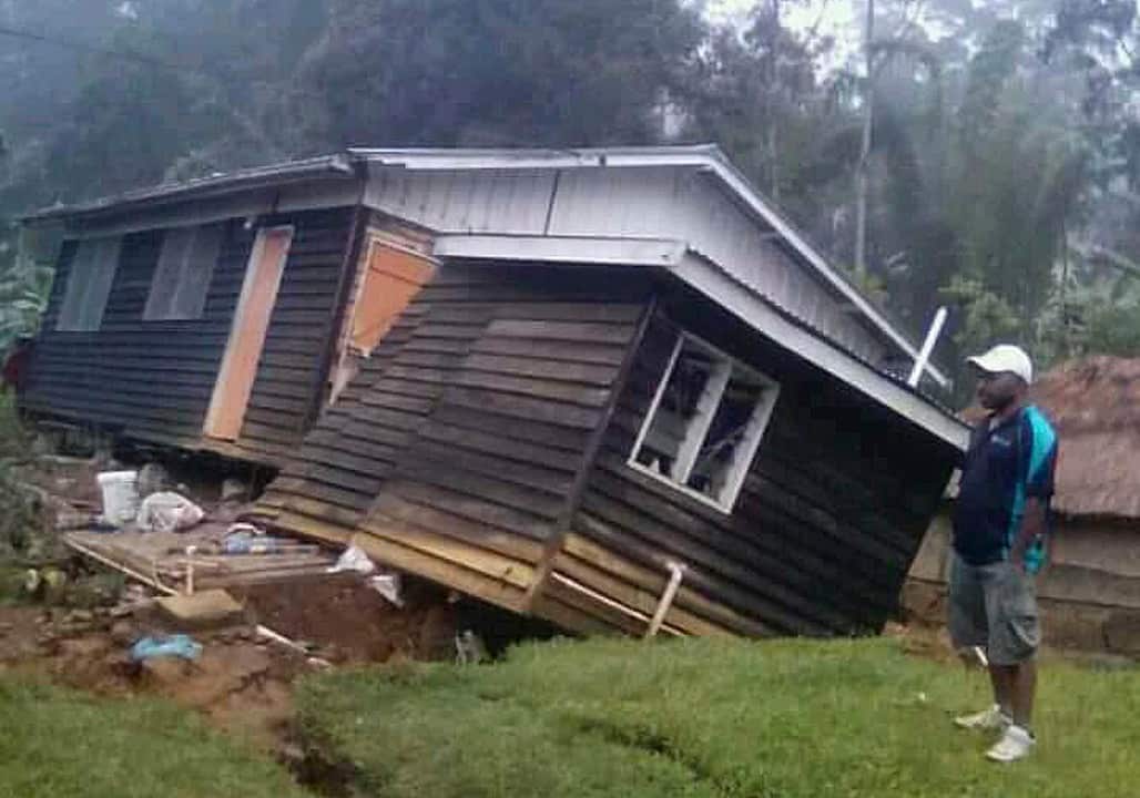 A man views a house that collapsed during February's strong quake in PNG.