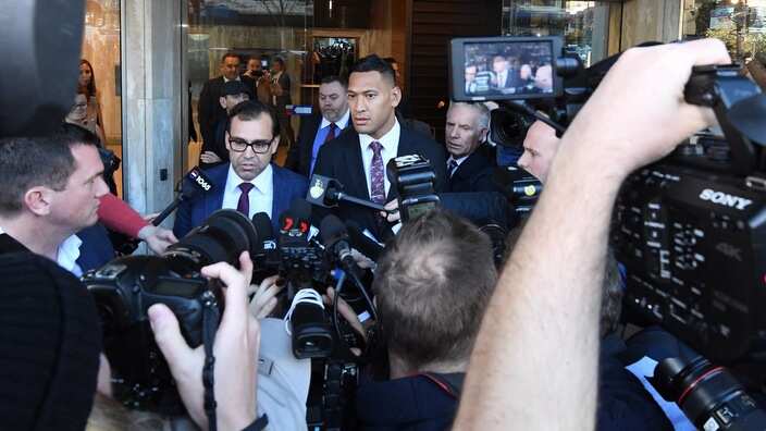 A media scrum surrounds Israel Folau after he leaves the Fairwork Commission 