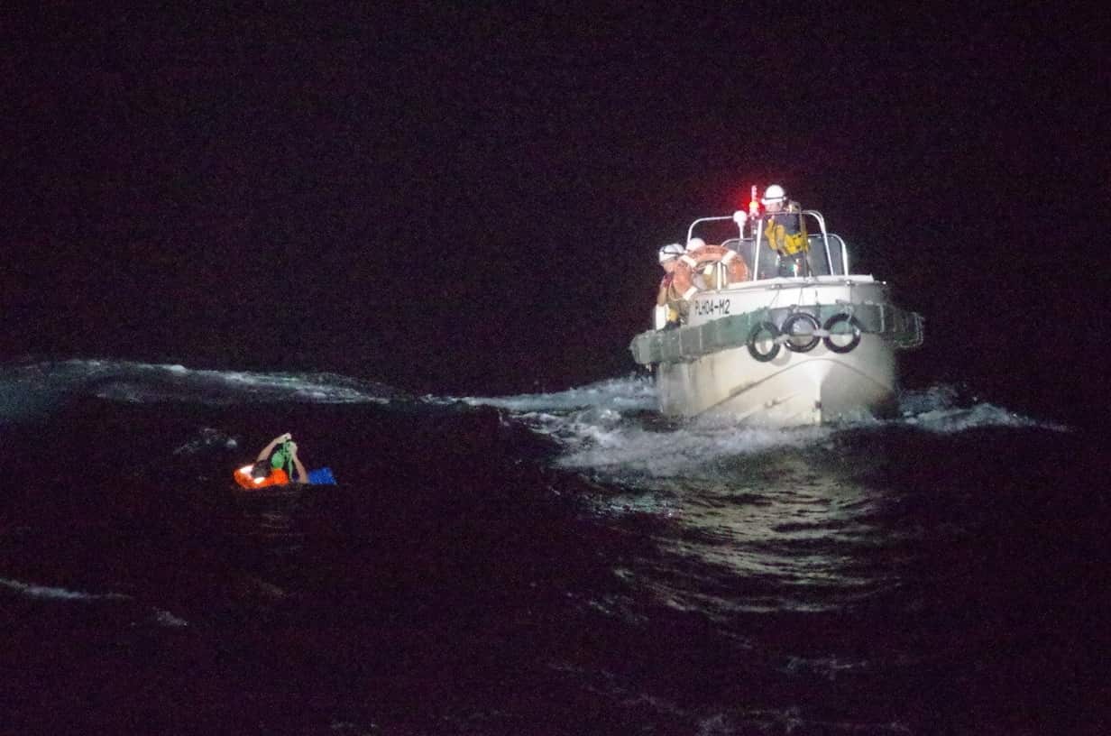Japan Coast Guard officers rescue a crew member of the capsized ship.