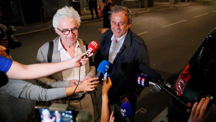 Michel Platini, right, and his lawyer William Bourdon answer reporters after Platini has been freed