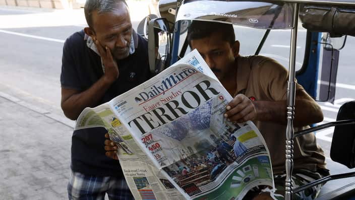 People read a newspaper the day after multiple blasts killed hundreds Sri Lanka,
