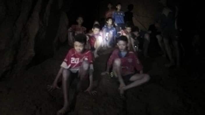 The boys and their coach inside the twisting, water-logged caverns. 