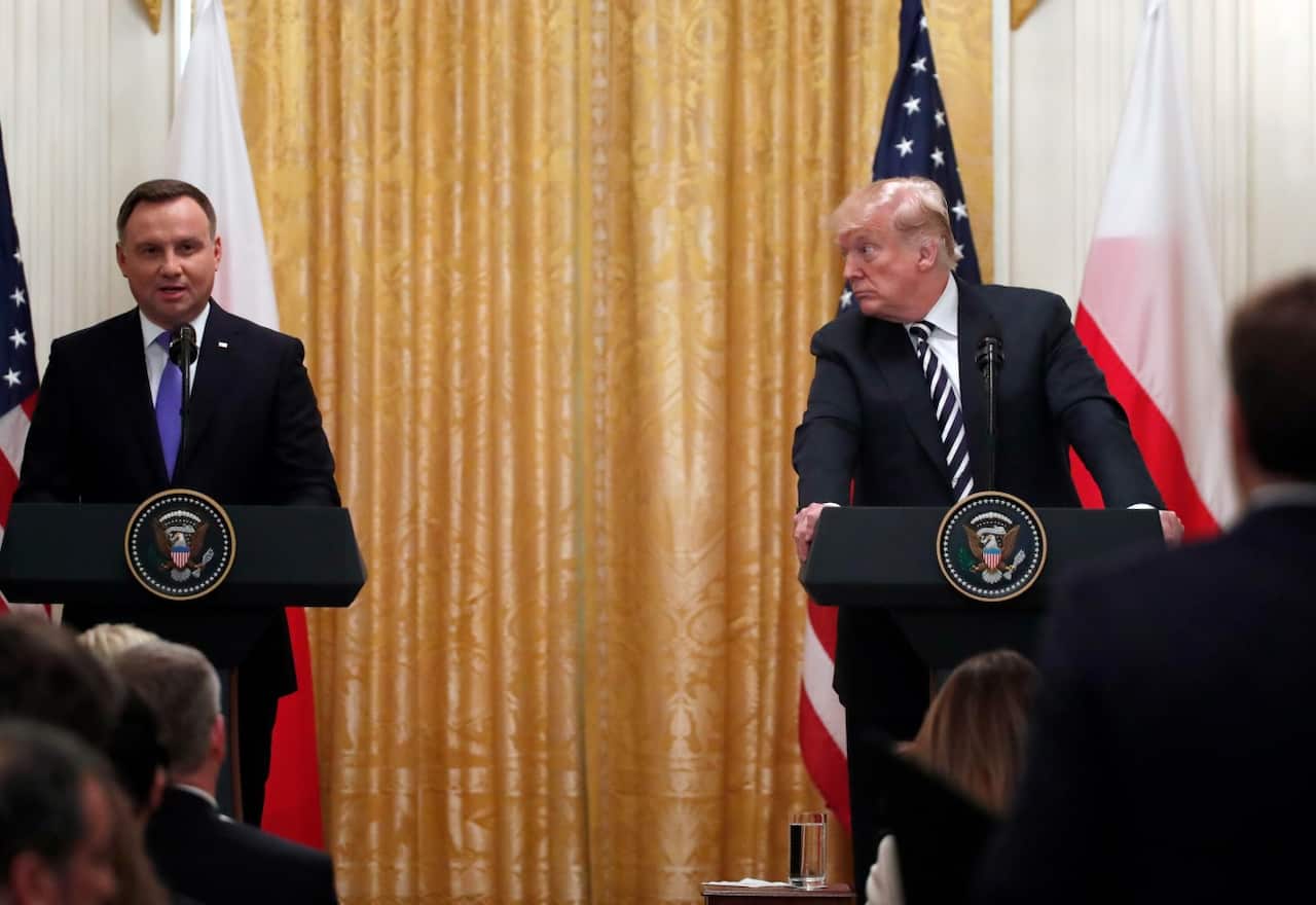 President Donald Trump looks at Polish President Andrzej Duda as he responds to a reporter's question, in the East Room of the White House, Tuesday, Sept. 18