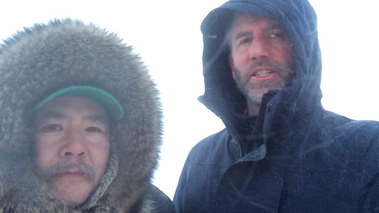 Aaron stops for a selfie in the snow with Arviat's polar bear monitor Leo Ikhakik.