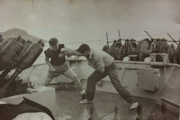 An old photograph of Patrick Syron boxing on deck.