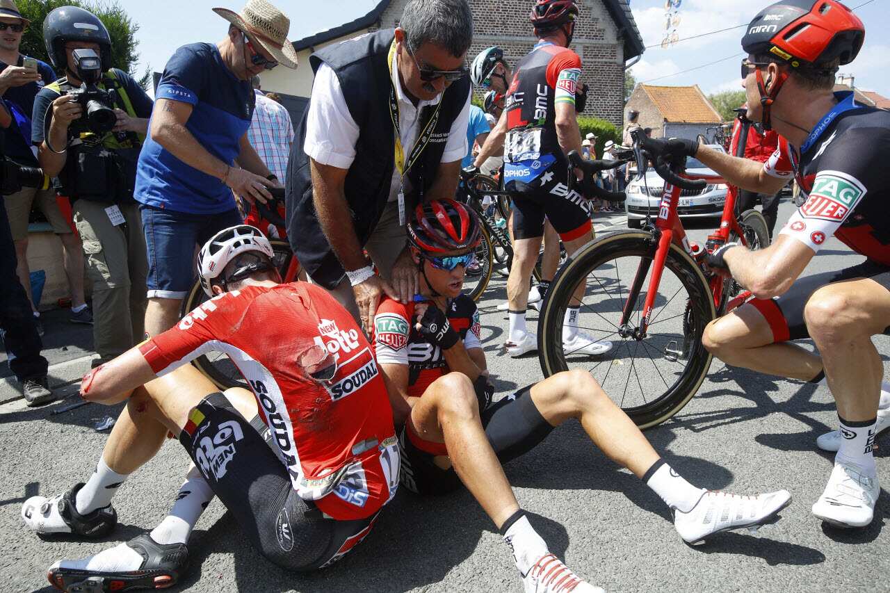 BMC Racing Team rider Richie Porte (C) receives medical assistance after crashing with Lotto Soudal team rider Jens Keukeleire (L) of Belgium.