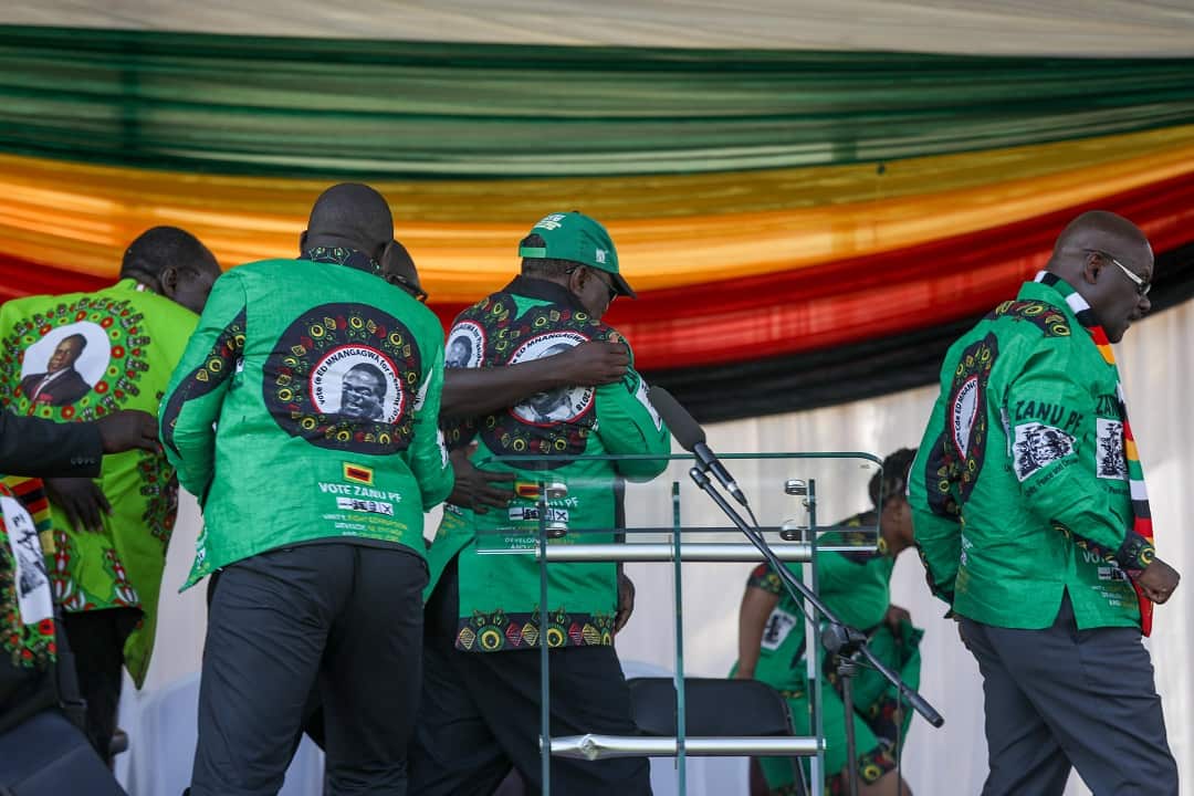 Zimbabwe's vice president Constantine Chiwengaaway is shielded and taken away after the bomb blast.