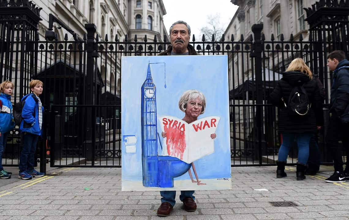 Political satirist Kaya Mar holds his painting of British Prime Minister Theresa May outside Downing Street.