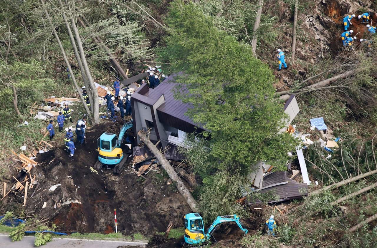 Police search missing persons at the site of a landslide after an earthquake in Atsuma town, Hokkaido, northern Japan, Thursday, Sept. 6, 2018.