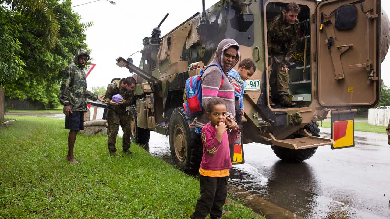 Army personal assist a family evacuating rising flood waters in Rosslea, Townsville.