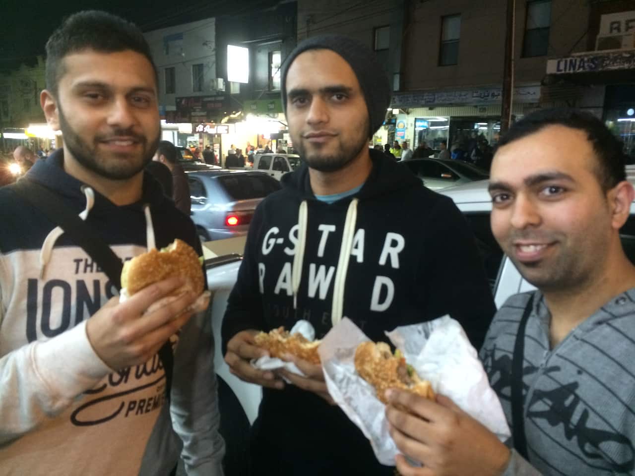 Men eating camel burgers during Ramadan (SBS)