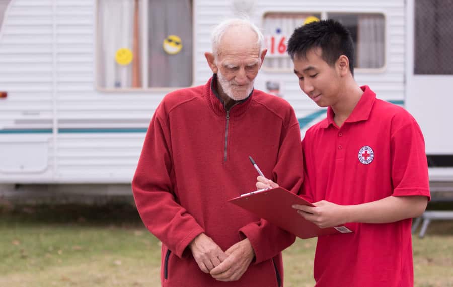 A member of the Australian Red Cross speaks with a bushfire survivor.